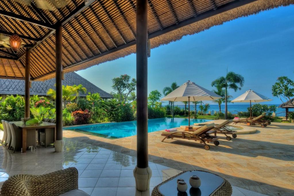 an image of a resort with a swimming pool at Beachfront Villa Nirwana with Private Jacuzzi in Pengastulan