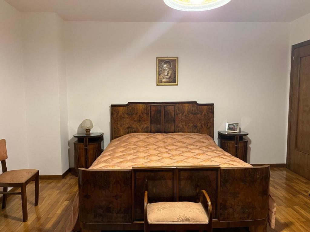 una camera con un grande letto in legno di Mountain home with sauna a Sùtrio