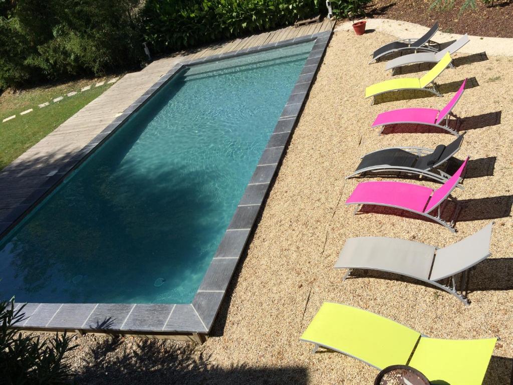 a group of chairs and a swimming pool at Le Robinson in Pierrelatte