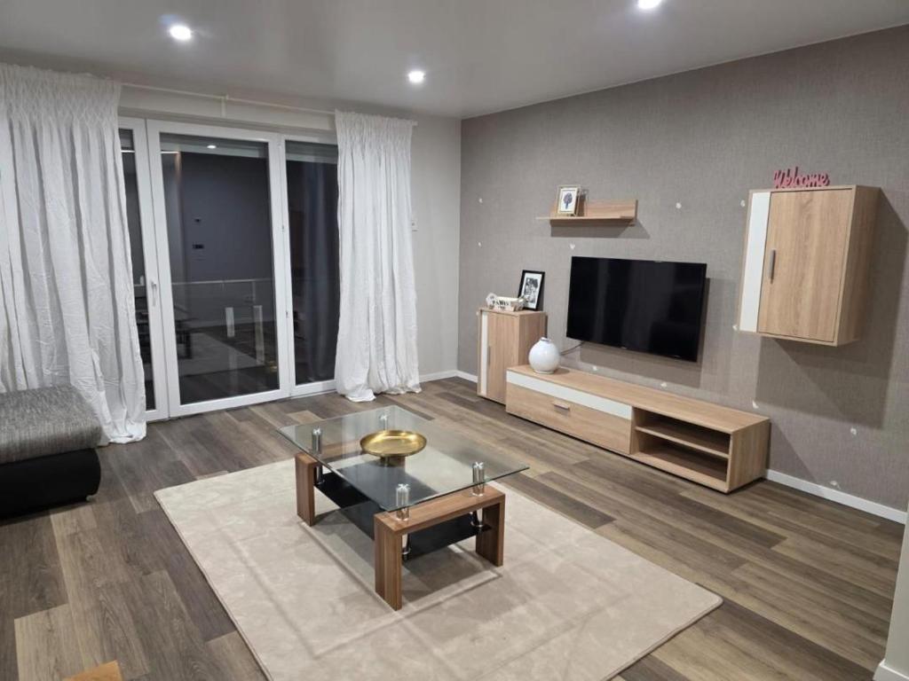 a living room with a flat screen tv on a wall at NEU! Modernes Wohnen Bad Berleburg in Meckhausen