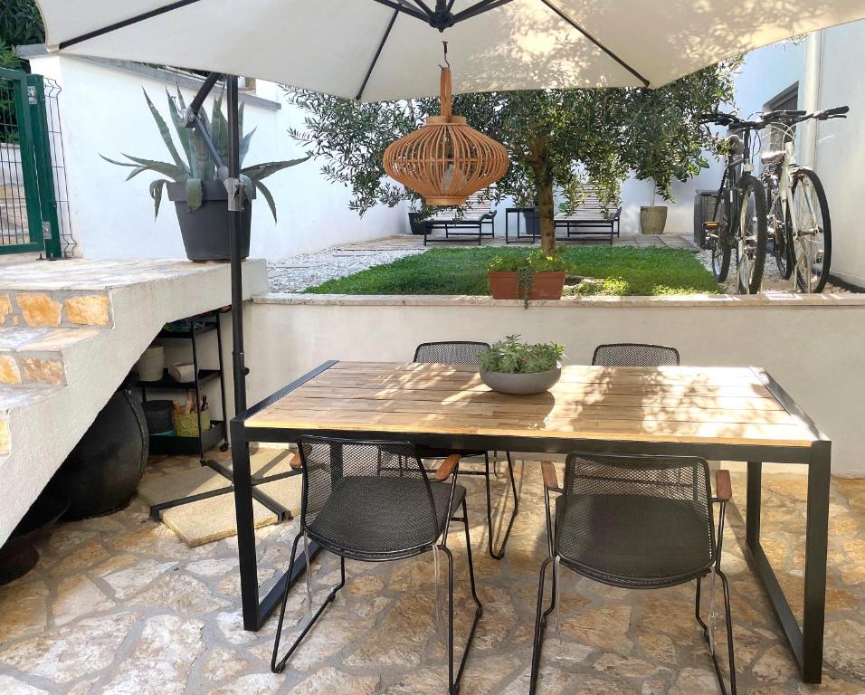 a table and chairs with an umbrella in a patio at Great outdoor living steps away from the beach in Sutivan