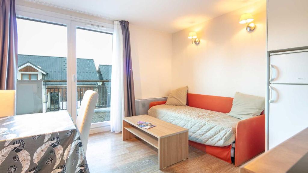 a living room with a couch and a large window at Les Balcons d Aix N701 2P6 in Les Déserts