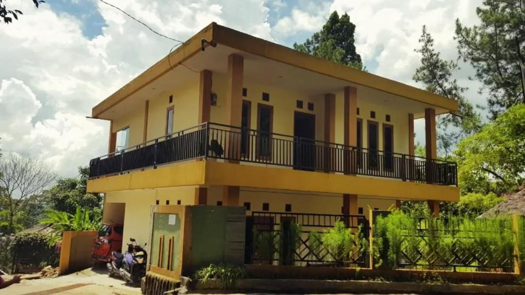 een geel huis met een motorfiets er voor geparkeerd bij Villa Montana Batulayang in Sampal 2