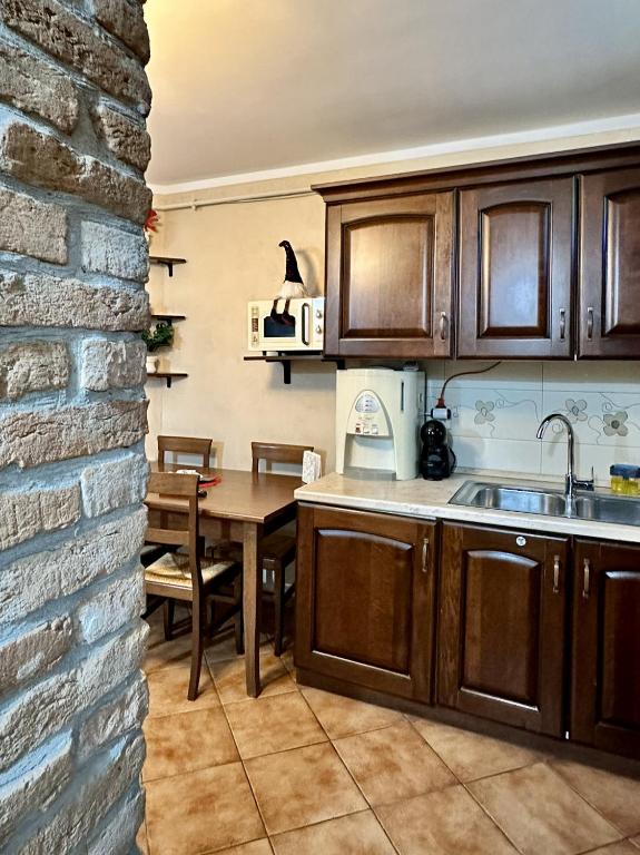 a kitchen and dining room with a table and a brick wall at 29 Nest Residence in Craiova