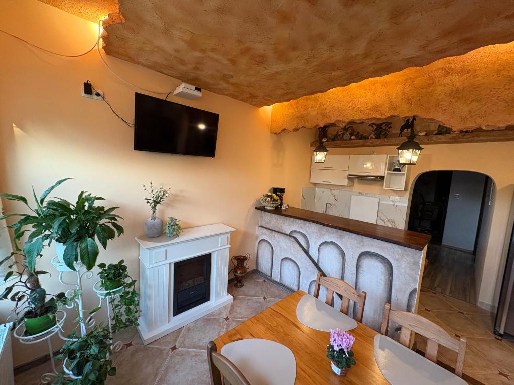 a living room with a table and a fireplace at Apartamenty Vesuvio in Dźwirzyno