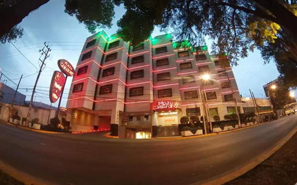 a large pink building with green lights on a street at Hot Plaza Camarones - Love Hotel - Solo Adultos in Mexico City