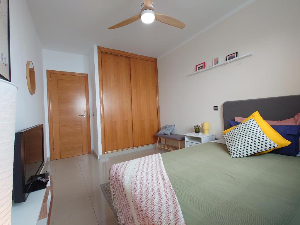 a bedroom with a bed and a ceiling fan at La Casita Suites in Puerto del Rosario