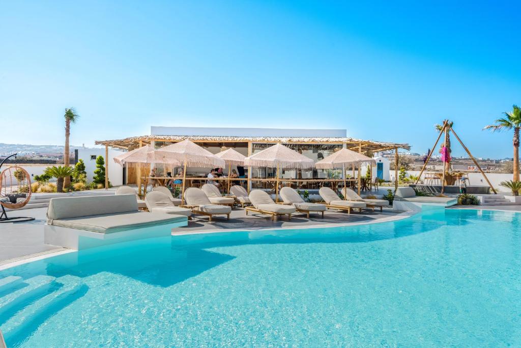 a swimming pool with lounge chairs and a resort at The Amethyst Exclusive Suites Oia in Oia
