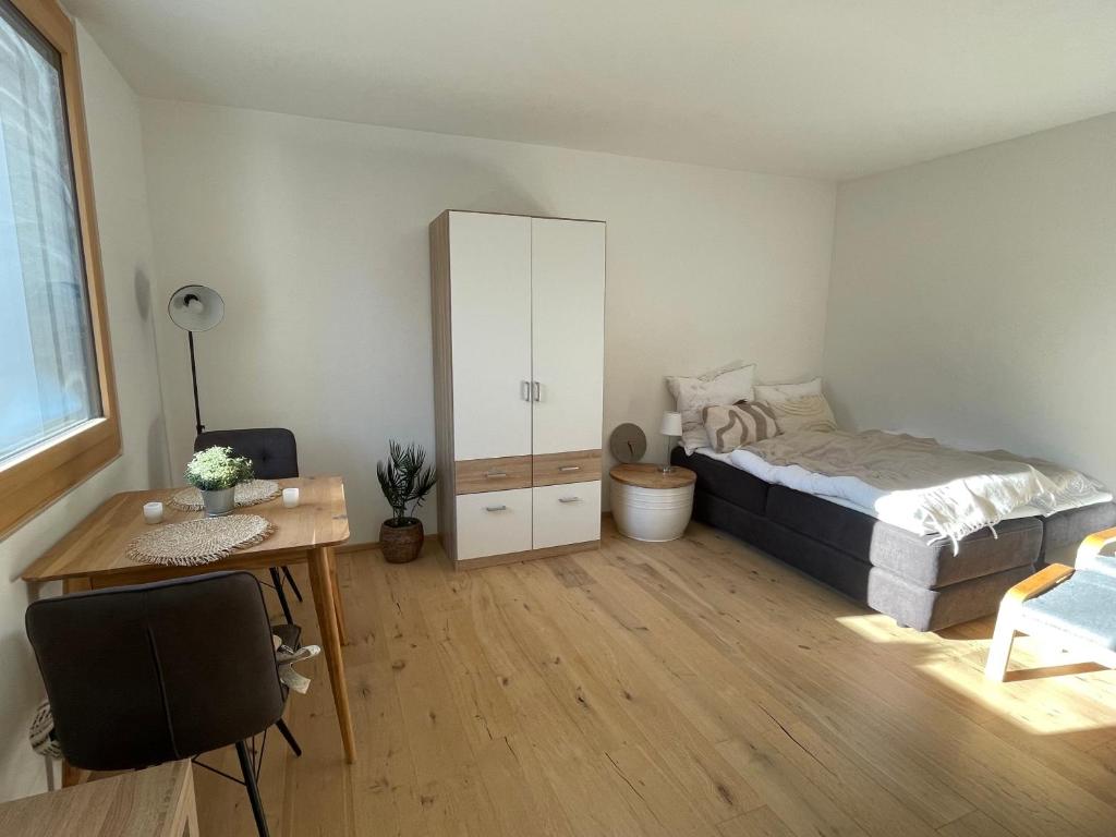 ein Schlafzimmer mit einem Bett, einem Schreibtisch und einem Spiegel in der Unterkunft Modernes & gemütliches Apartment in Zentrumsnähe in Kempten