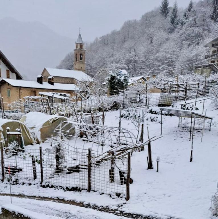 Carmen2 في Miroglio: قرية مغطاة بالثلج مع كنيسة في الخلفية