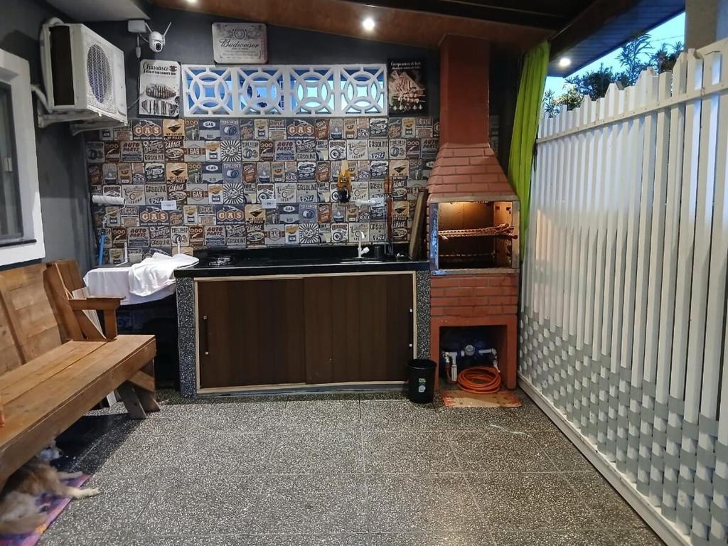 een buitenkeuken met een fornuis en een wastafel bij Casa aconchegante e familiar em Matinhos in Matinhos