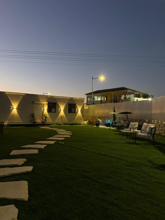 - une cour avec des chaises et un bâtiment la nuit dans l'établissement אחוזת תכשיט, à Sifsufa