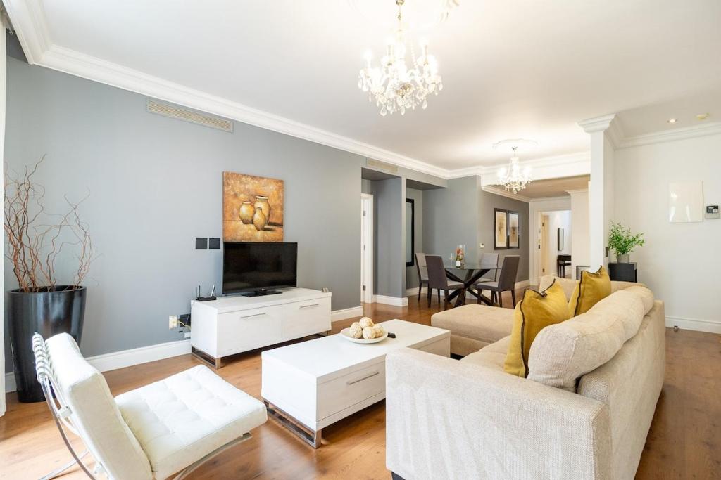 a living room with a couch and a tv at Cape Royale Elegance & Comfort in Cape Town