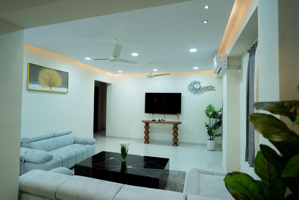 a living room with a couch and a tv at Le Penguin Serviced Apartments in Madhapur