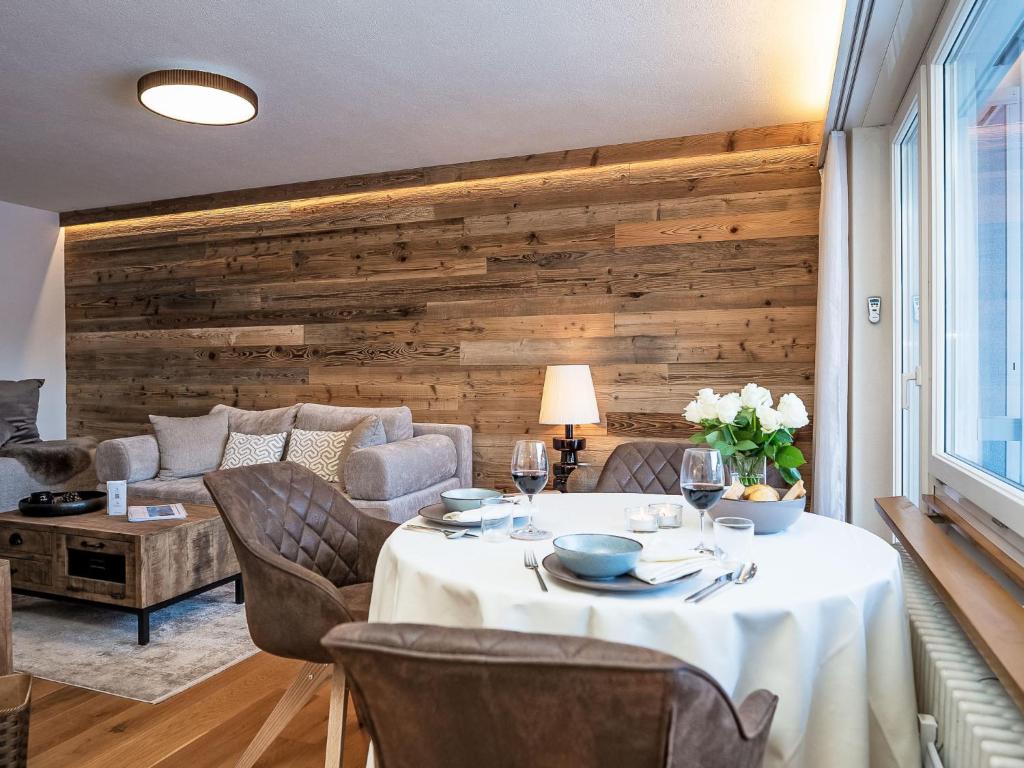 een eetkamer met een tafel en een bank bij Apartment Chesa Fleury by Interhome in St. Moritz