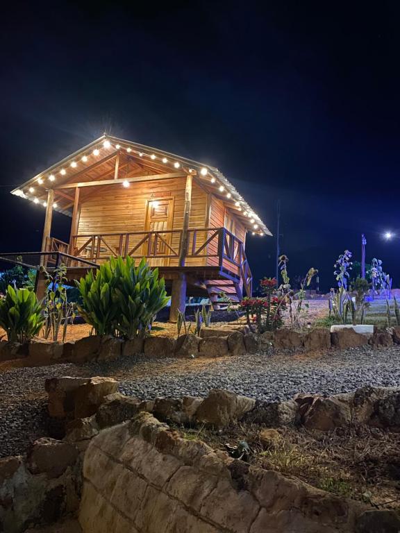 eine Holzhütte mit Nachtlicht in der Unterkunft Gran Vista Glamping Curití in Curití