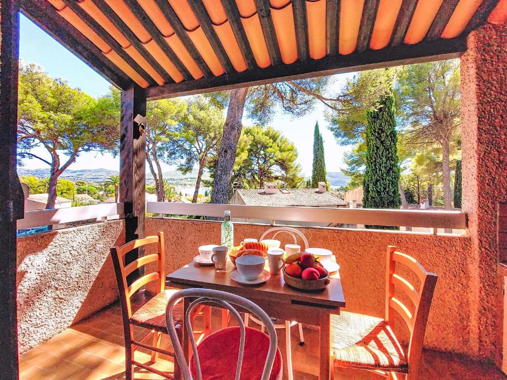 - une table en bois avec un bol de fruits sur une terrasse couverte dans l'établissement Studio Les Hauts du Port-1 by Interhome, à Saint-Cyr-sur-Mer