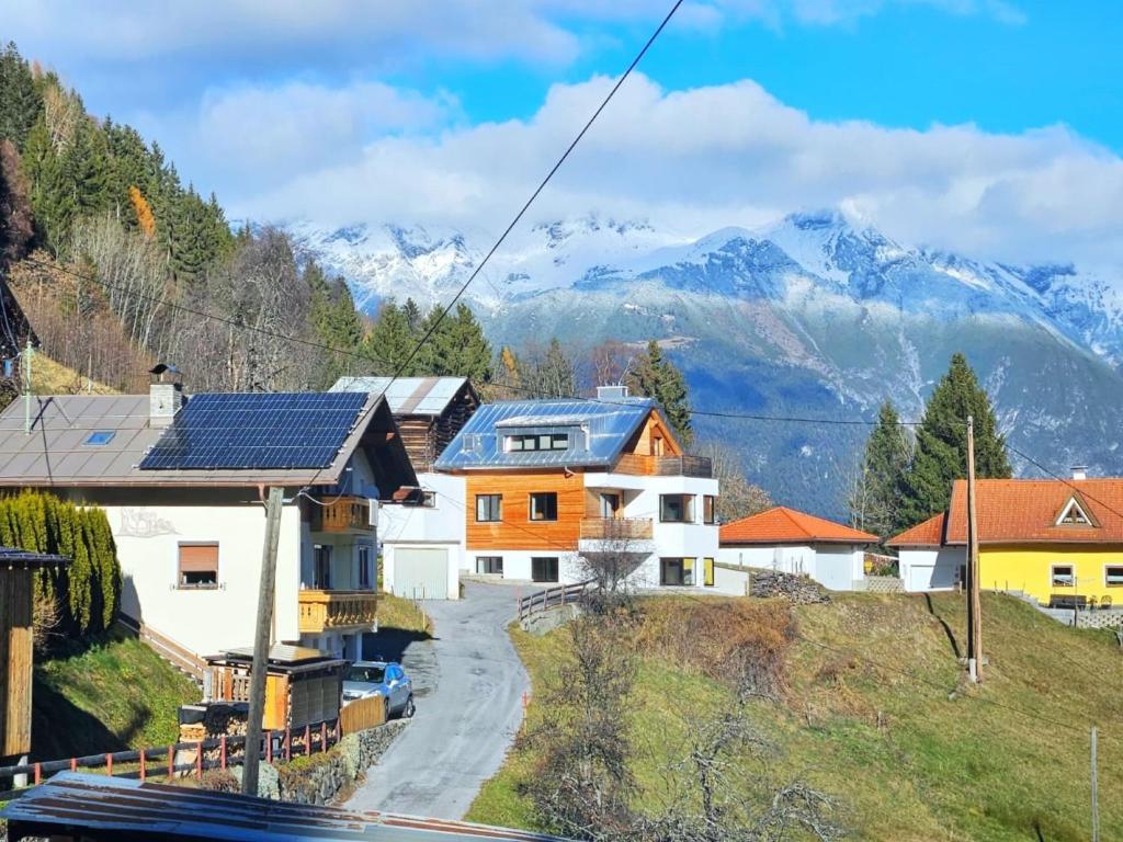 a group of houses with mountains in the background at Apartment Home Holzwurm by Interhome in See