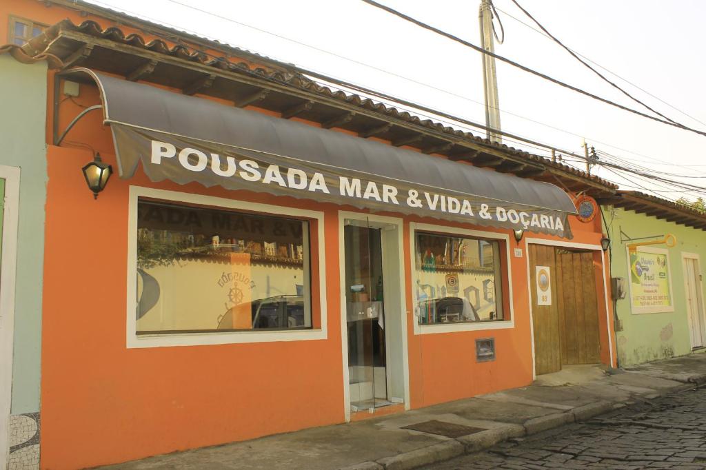 an orange building with a sign that reads pousada mar navaho and hospital at Pousada Mar & Vida e Doçaria in Paraty