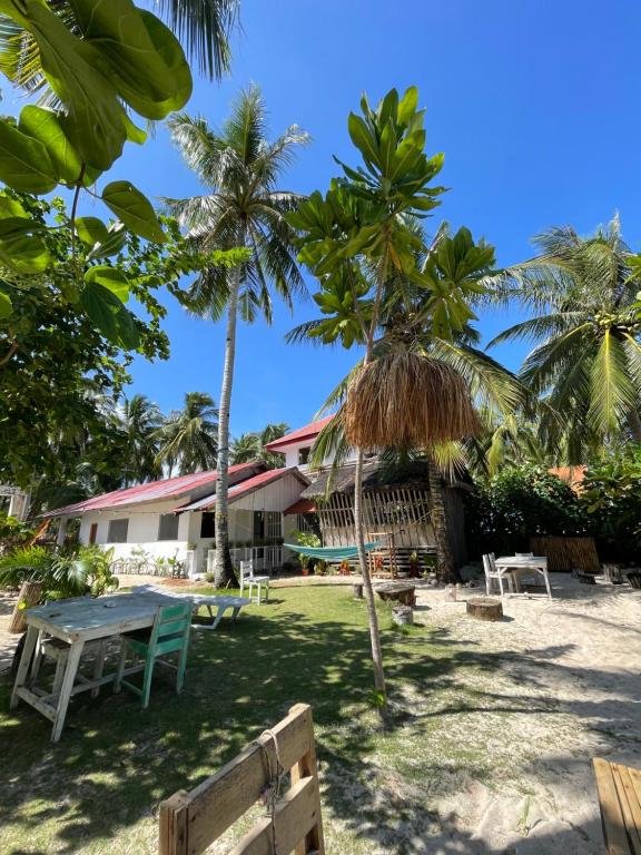 a picnic table and palm trees in front of a resort at Casa Alegria Beach Rooms in Alegria