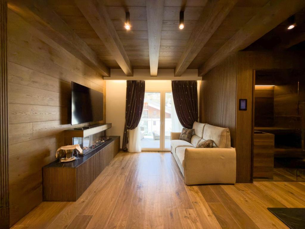 ein Wohnzimmer mit Sofa und Fernseher in der Unterkunft Luxury Mountain Suites in Roccaraso