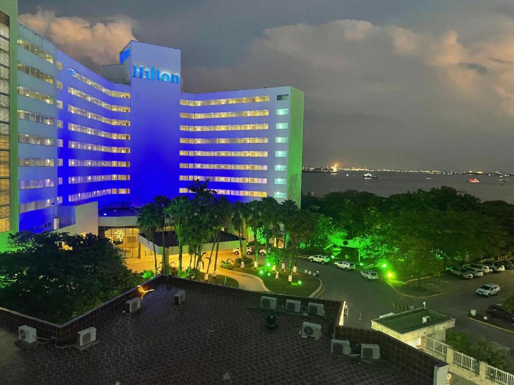 een groot gebouw met blauwe lichten op een parkeerplaats bij Marèlago Apartamentos in Cartagena