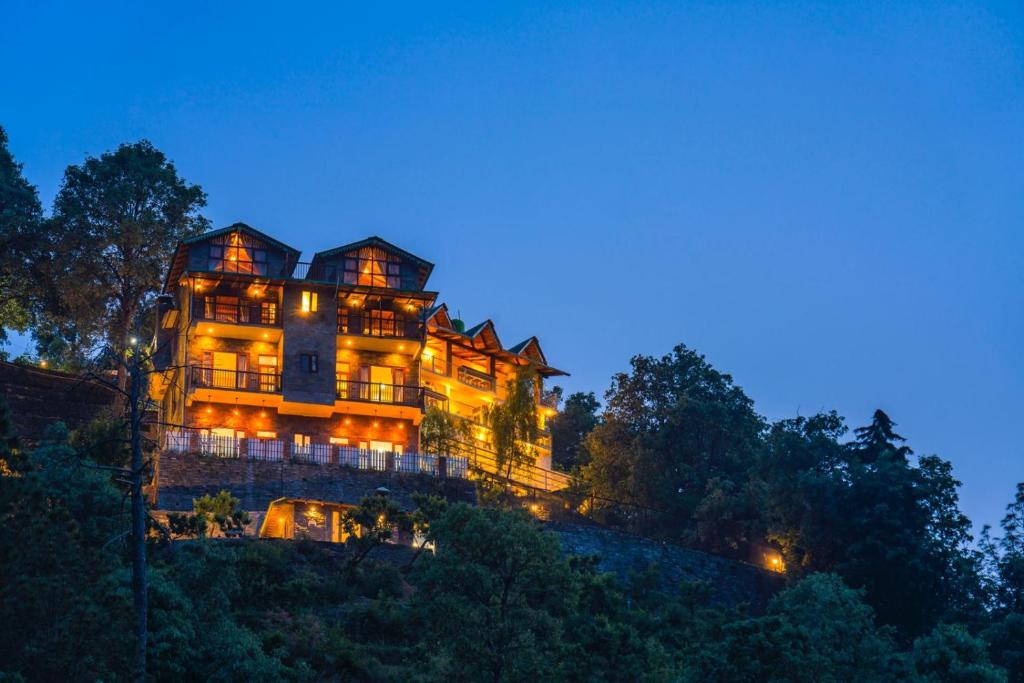 een groot huis op de top van een heuvel 's nachts bij Indulge Ramgarh by PACK in Rāmgarh