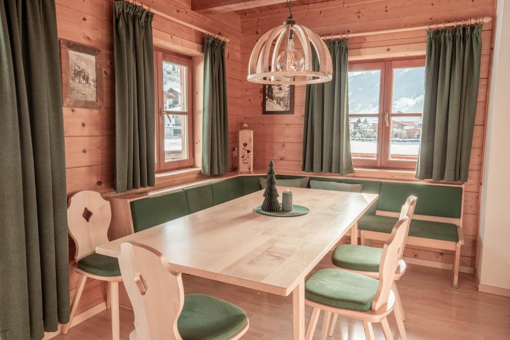 a dining room with a wooden table and chairs at Astlhof in Grossarl