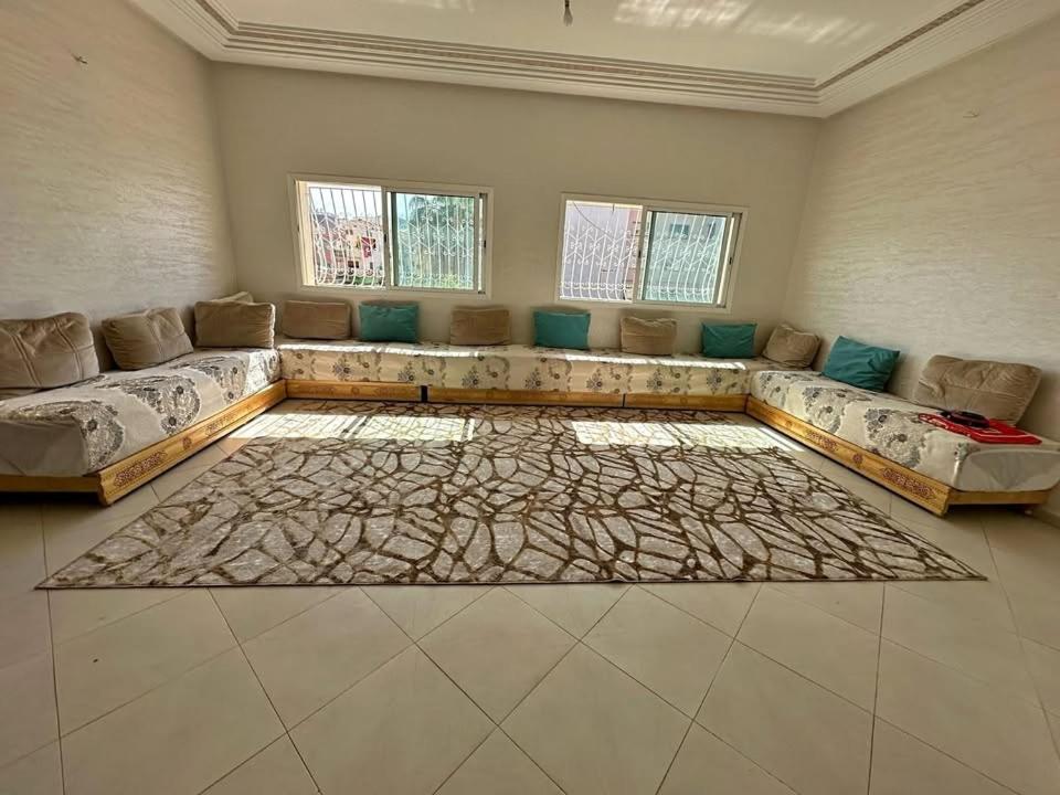 sala de estar amplia con sofá y alfombra en Résidence Al Hayat Agadir, en Aourir
