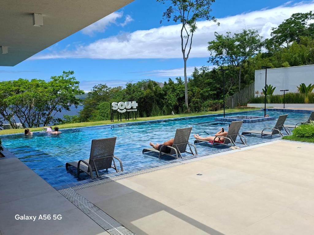 a group of people laying in chairs in a swimming pool at Vista Mar Icaraí Ingá in Niterói