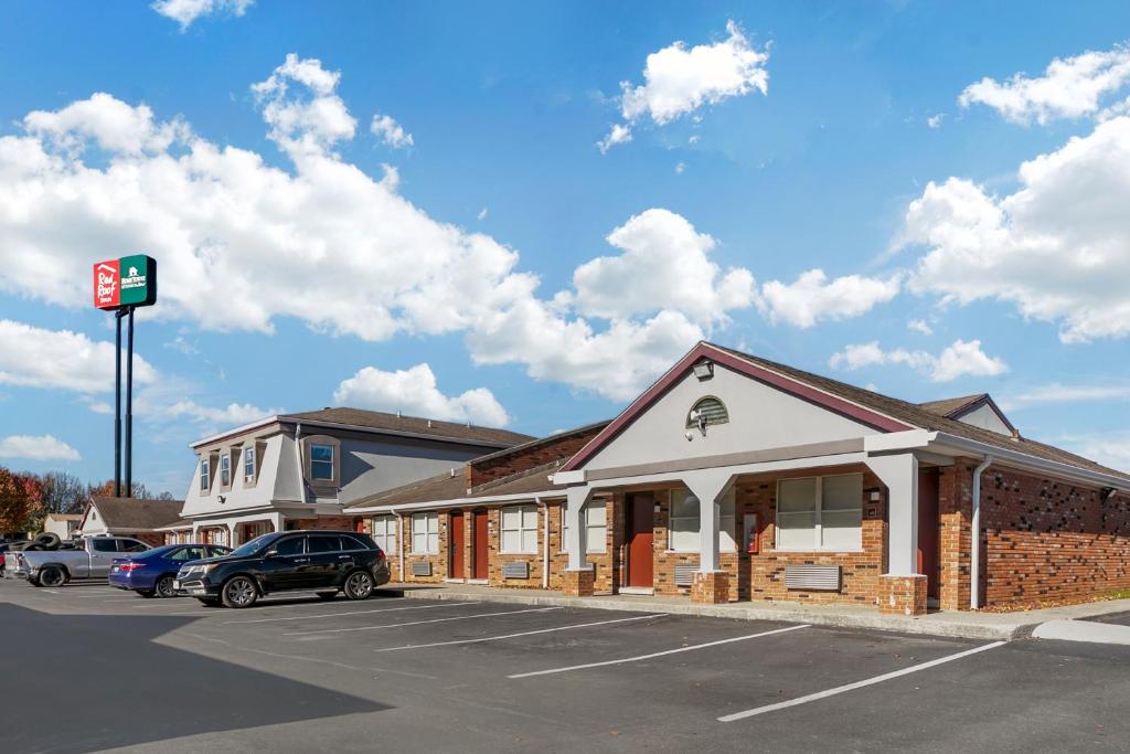 ein Gebäude mit einem auf einem Parkplatz geparkten Auto in der Unterkunft HomeTowne Studios by Red Roof Georgetown, KY in Georgetown