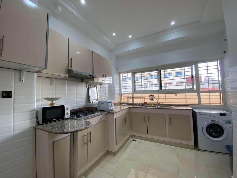 een keuken met een spoelbak en een wasmachine bij Résidence Al Manadir Agadir in Aourir