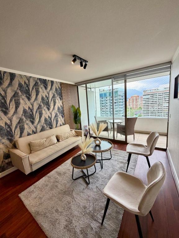 een woonkamer met een bank en tafels en stoelen bij Sky Park Elite in Santiago