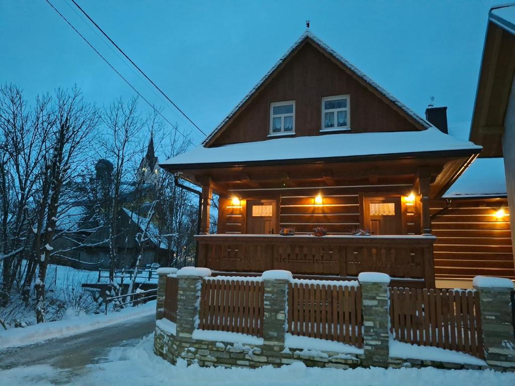 a log cabin with a fence in the snow at Chalet Maria Lendak in Lendak