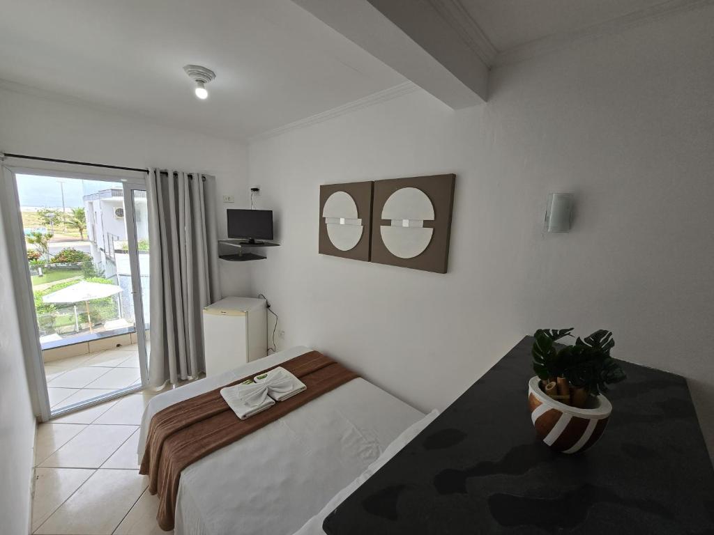 een slaapkamer met een bed en twee spiegels aan de muur bij Pousada Mar Alto in Ilha Comprida