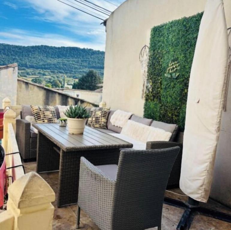 eine Terrasse mit Tisch und Stühlen auf einem Balkon in der Unterkunft Maison de village familiale Sablet in Sablet