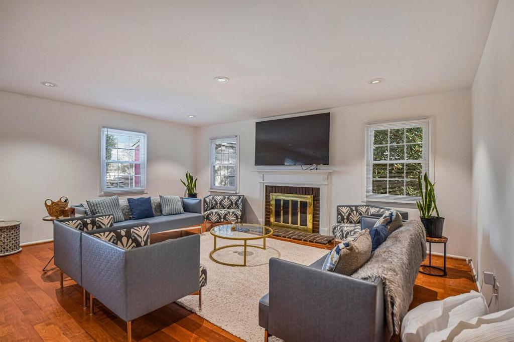 een woonkamer met banken en een open haard bij Cozy 4BR Retreat - Private backyard, Gazebo & Grill in Fairfax