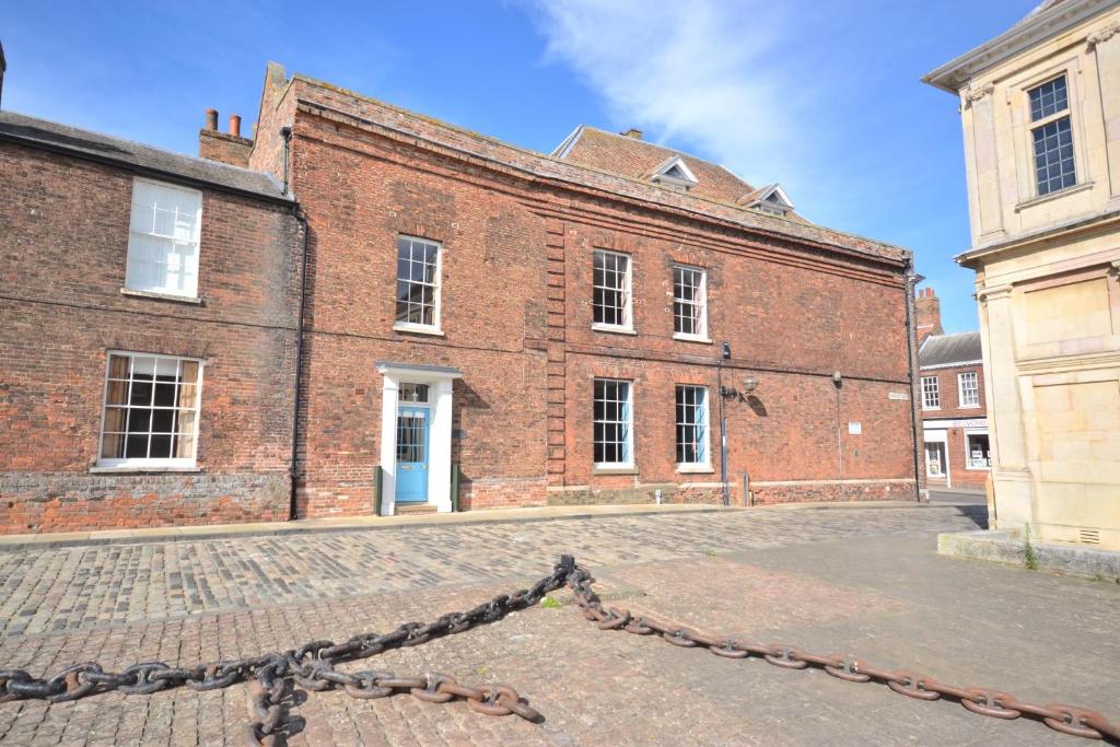 a large brick building with a chain in front of it at 1 Purfleet Quay in King's Lynn