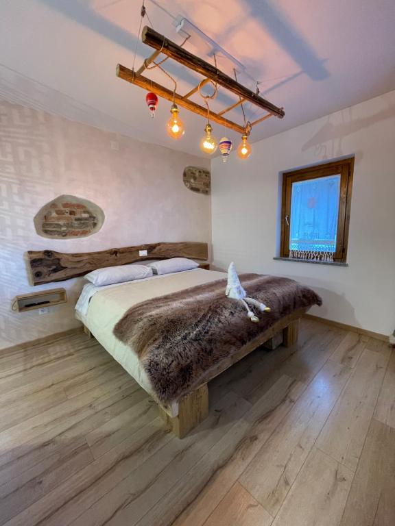 ein Schlafzimmer mit einem großen Bett mit Holzboden in der Unterkunft Emozioni al Lago in Farra dʼAlpago
