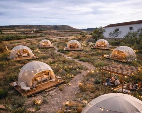 Eine Gruppe von Kuppeln auf einem Feld mit Menschen darin in der Unterkunft Glamping De Castilla in Guadalajara