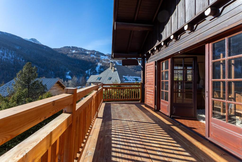 un balcone in legno con porta su un edificio di South-facing Chalet With Views a Le Villard-Late