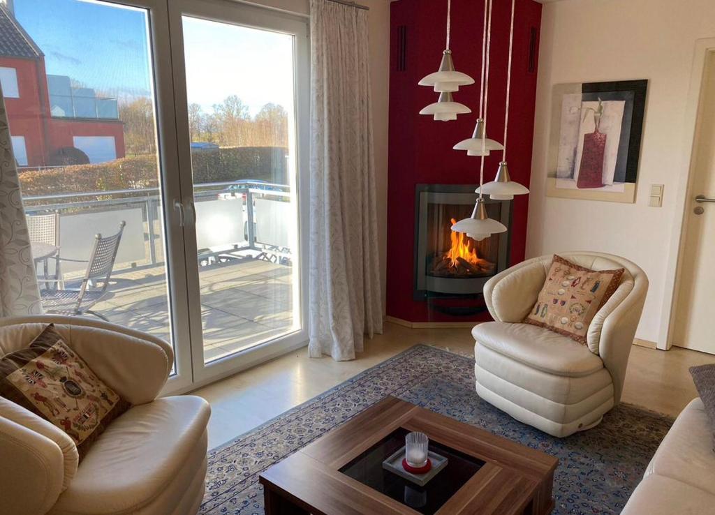 a living room with a couch and chairs and a fireplace at "Villa Harmonie" direkt am Golfplatz in Göhren-Lebbin