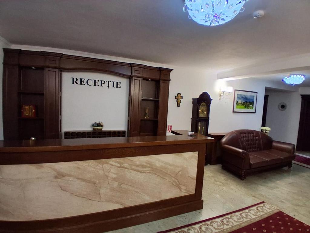 een lobby met een receptie en een stoel bij Pensiunea Casa Barsan in Bîrsana