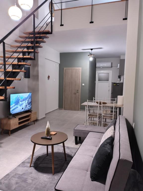 een woonkamer met een bank en een tv bij Konstantinos Loft in Serres