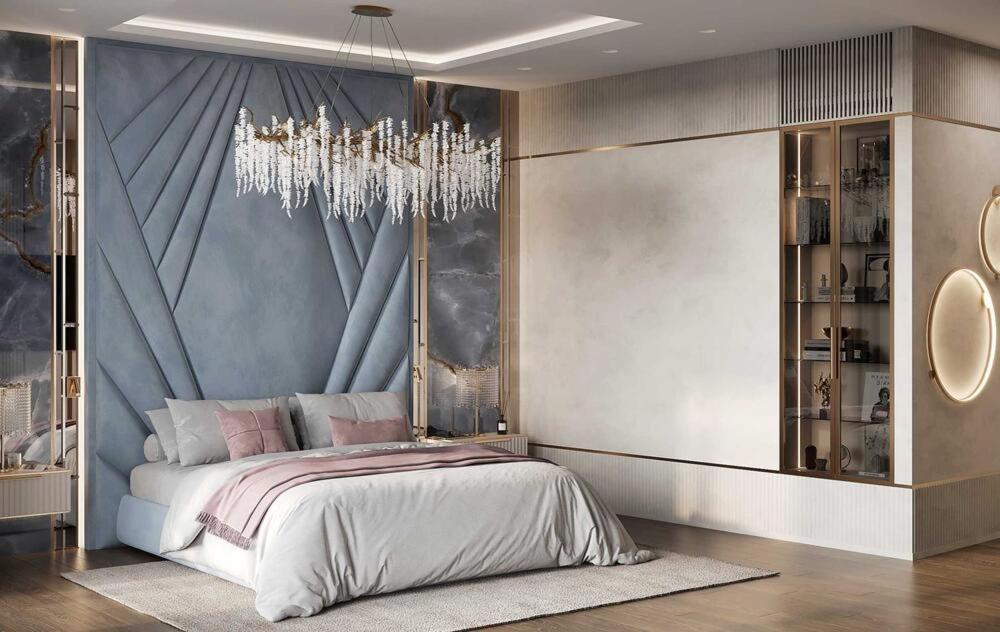 een slaapkamer met een groot bed en een kroonluchter bij MEGA Almaty ATRIA in Alma-Ata