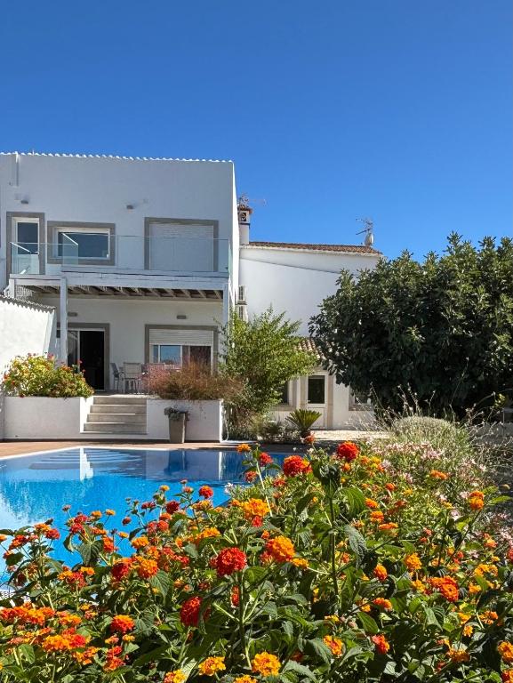 a house with a swimming pool and flowers at Casa Bravo in Querença