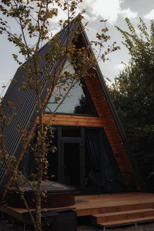 a cabin with a pitched roof with a large window at Aframe Shepit in Sosnovka