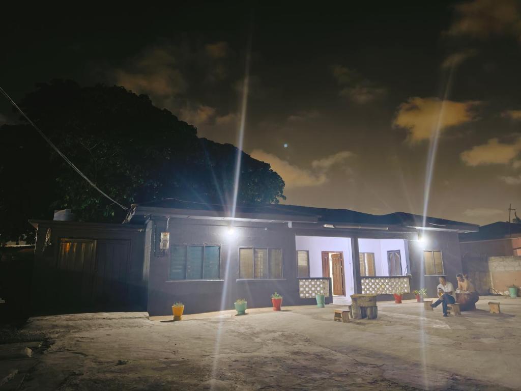 een paar mensen die 's nachts voor een gebouw zitten bij huazhi in Accra