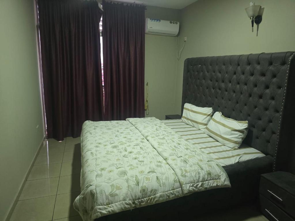 a bedroom with a large bed with a large headboard at Dream Land in Lagos