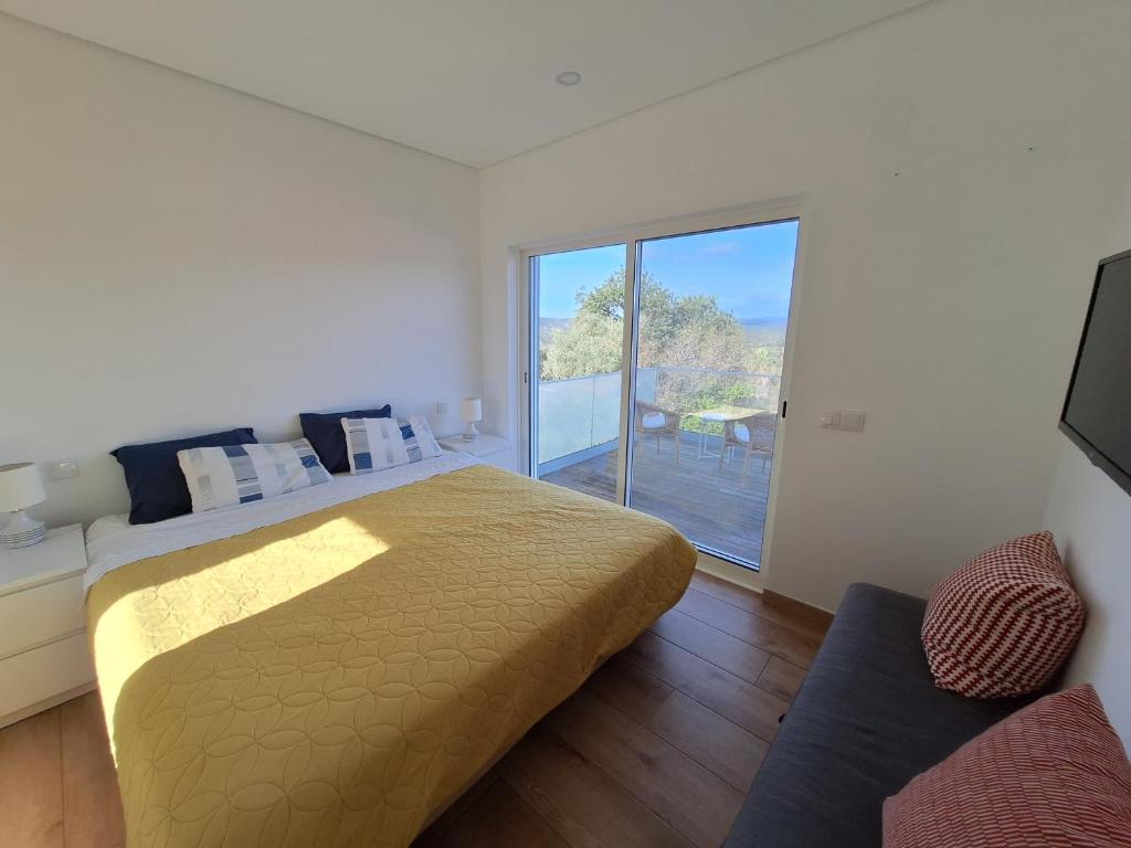 una camera da letto con un letto grande e una grande finestra di Casa Bravo a Querença